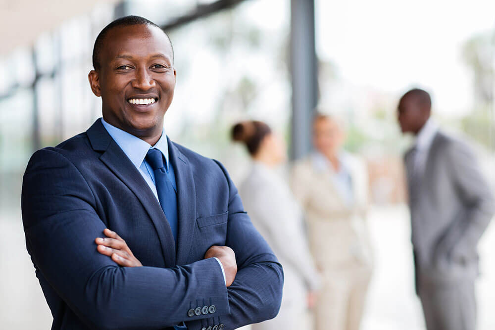 smiling man with crossed arms wearing a suit