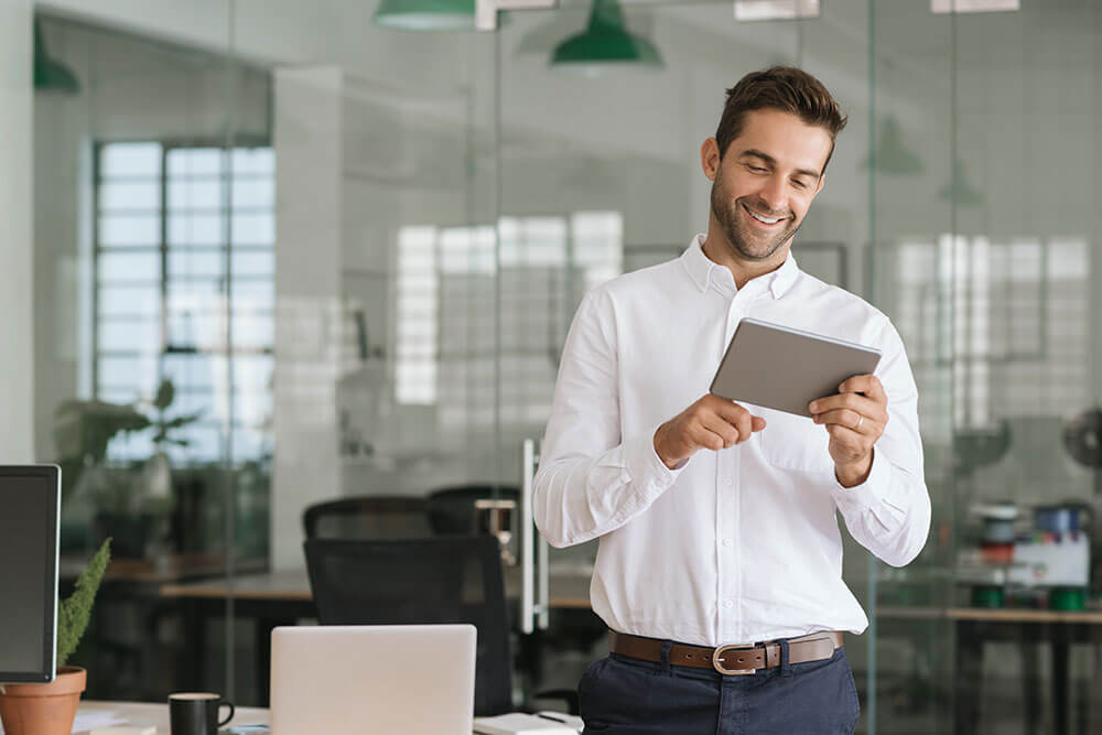 smiling man looking at an ipad